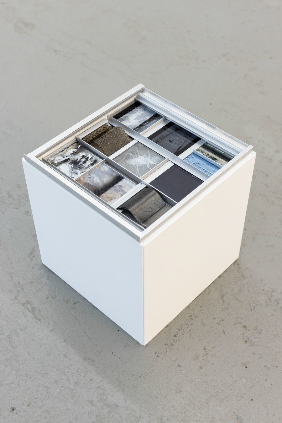 Sebastian Haas, “Between Glass and Wall”; from the Solo Show “Reminisce-Supports” at KALI Gallery, Lucerne, CH; Oil, spraypaint on reverse glass, plexiglass, carbon, aluminium, wood; 35 x 35 x 35 cm, 2025. Courtesy of the Artist and KALI Gallery. Photo by Kim da Motta