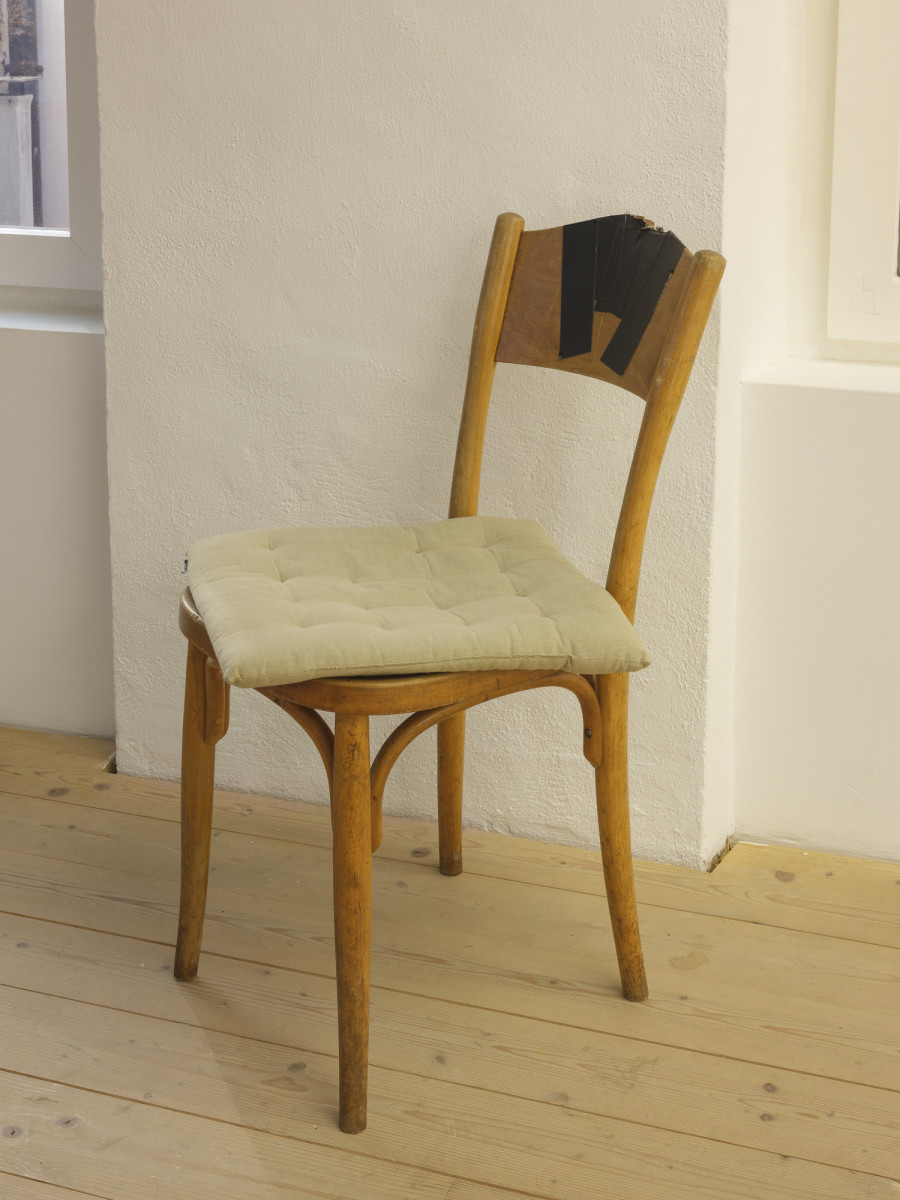 (2003), Wooden chair repaired with black gaffer tape, beige cushion used around the CAN office table, 2025. Photography: Sebastian Verdon. Courtesy: All images courtesy of the artists and CAN Centre d’art Neuchâtel