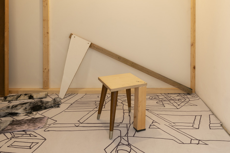 Detail of Aldo Mozzini, Quasi un rifugio, 2025. Drawing, large poster on poster paper, 356 x 504 cm – MDF panels, window with design made with yoghurt, bituminous paper, white wooden flag, stool, lamp, intaglio printing fabrics, plastic waste, various types of wood, 220 x 280 x 140 cm. Ph by Riccardo Giancola. Images courtesy of artists and La Rada, Photography by Riccardo Giancola (@riccardo_giancola) and Emanuele Finardi (@e.m.hey)