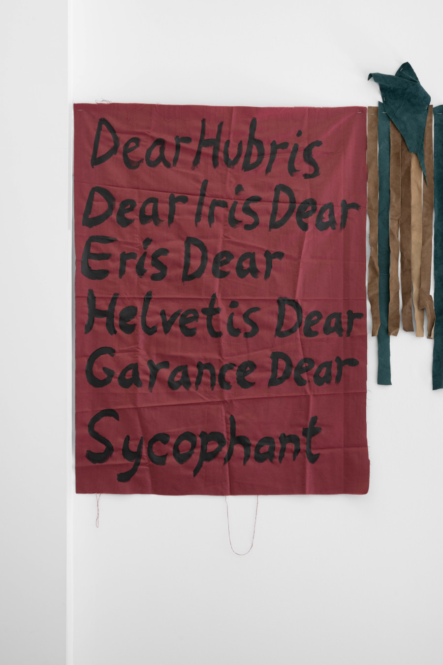 Billy Morgan, Left: Red Letters (Hubris), 2025, acrylic on fabric, 106 x 80 cm, Right: Bridges (2), 2025, leather, 91 x 34 cm. Installation view from the solo show Lackadaisies, curated by marytwo, jevouspropose, Zurich, 2025. Courtesy the artist and marytwo. Photo: marytwo, Elvira Baettig