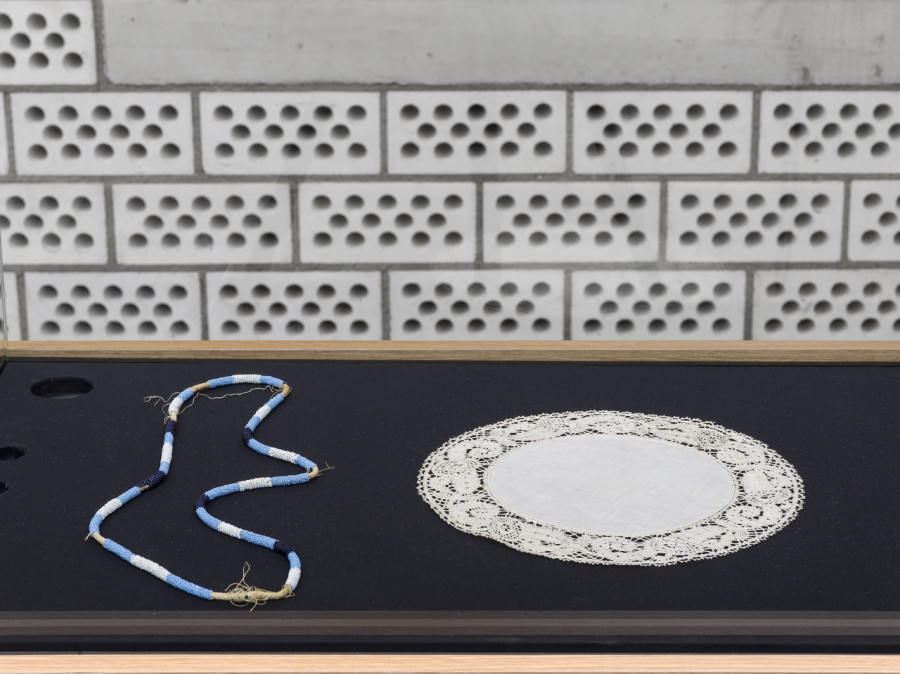 Exhibition view Sophie Taeuber-Arp / Mai-Thu Perret «Ich bin wü ü ü ü ü ü ü ü tend», Cabaret Voltaire 2022; Sophie Taeuber-Arp, Glass bead necklace, undated; decorative blanket circa 1916, design: Sophie Taeuber-Arp, manufacture: Alice Frey-Amsler. Photo: Cedric Mussano