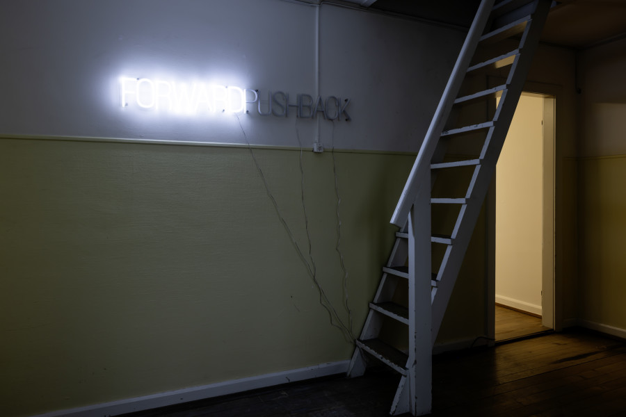 Exhibition View Solo Show Yota Tsotra «Wor(l)ds of borders; view on Yota Tsotra, Pushback/Forward, 2025, programmed light text sign, 140 cm x 15 cm» at Peripherie 8, Basel, 2025 / Photo: Stefan Schmidlin / Courtesy: Peripherie 8