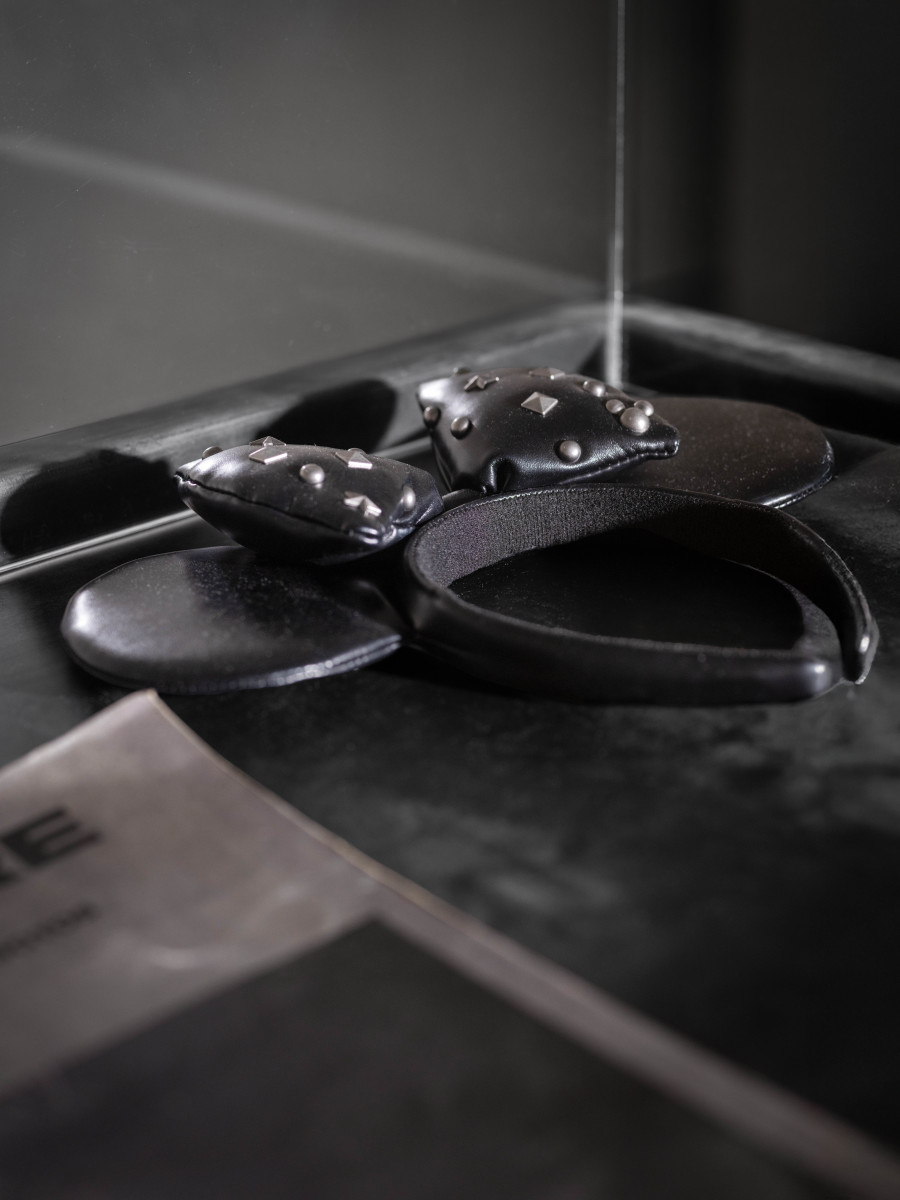 Julian-Jakob Kneer, FANATIC (8) (Detail), 2025, Archival Satanic Bible, WWJD bracelet, Disneyland Tokyo headband, archival Peter Sotos PURE #1 zine, cast rubber and acrylic glas vitrine, 76 x 54 x 35 cm. Courtesy the artist and Blue Velvet, Zurich. Exhibition views by Andrea Luca Ammann.