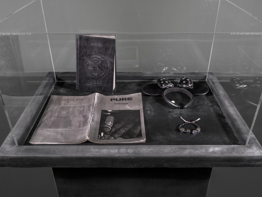 Julian-Jakob Kneer, FANATIC (8), 2025, Archival Satanic Bible, WWJD bracelet, Disneyland Tokyo headband, archival Peter Sotos PURE #1 zine, cast rubber and acrylic glas vitrine, 76 x 54 x 35 cm. Courtesy the artist and Blue Velvet, Zurich. Exhibition views by Andrea Luca Ammann.