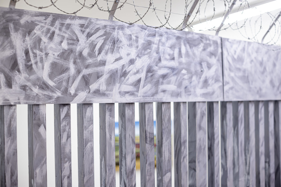 Exhibition View Solo Show Yota Tsotra «Wor(l)ds of borders»; view on Yota Tsotra, Fence, 2025, wood, metal, concrete, acrylic and PU lack, 424 cm x 226 cm x 15 cm» at Peripherie 8, Basel, 2025 / Photo: Stefan Schmidlin / Courtesy: Peripherie 8