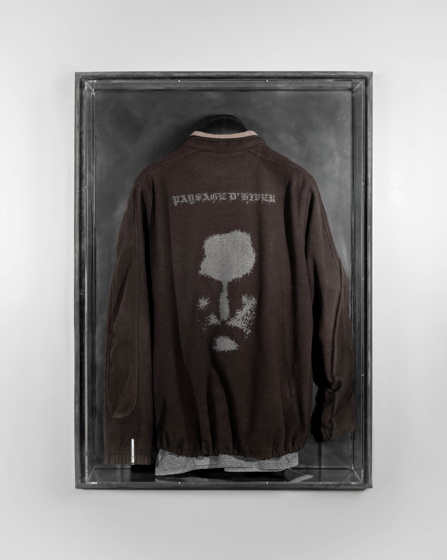 Julian-Jakob Kneer, FANATIC (6), 2025, Archival Paysage d'Hiver fleece jacket, Laibach tie pin, Precious Moments t-shirt,
cast rubber and acrilyc glas vitrine, 106 x 76 x 22 cm. Courtesy the artist and Blue Velvet, Zurich. Exhibition views by Andrea Luca Ammann.