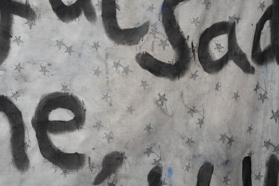 Billy Morgan, Detail of Red Letters (Religious), 2025, acrylic on fabric, Chanel N°19 208 × 116 cm. On view at the solo show Lackadaisies, curated by marytwo, jevouspropose, Zurich, 2025. Courtesy the artist and marytwo. Photo: marytwo, Elvira Baettig