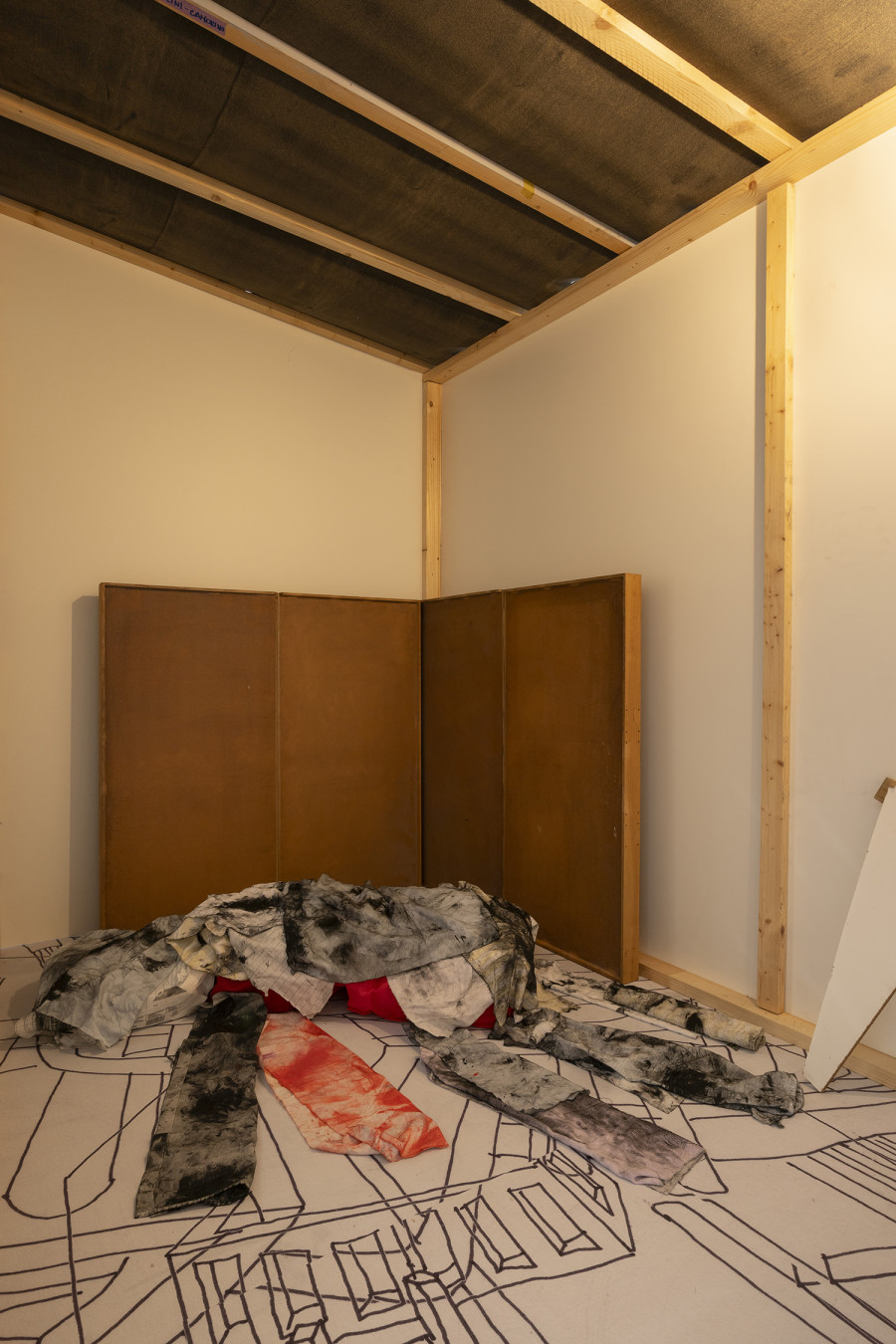 Detail of Aldo Mozzini, Quasi un rifugio, 2025. Drawing, large poster on poster paper, 356 x 504 cm – MDF panels, window with design made with yoghurt, bituminous paper, white wooden flag, stool, lamp, intaglio printing fabrics, plastic waste, various types of wood, 220 x 280 x 140 cm. Ph by Riccardo Giancola. Images courtesy of artists and La Rada, Photography by Riccardo Giancola (@riccardo_giancola) and Emanuele Finardi (@e.m.hey)